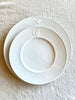 white charger with greek medallion design with dinner plate on top