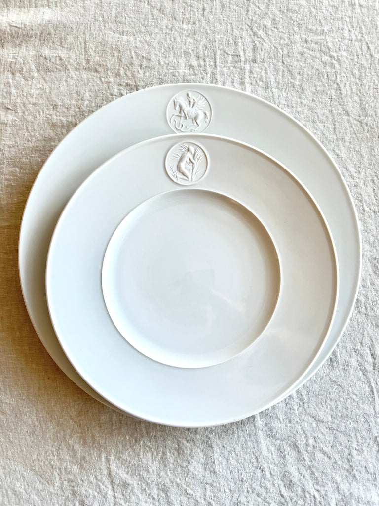 white dinner plate with greek medallion design on top of charger