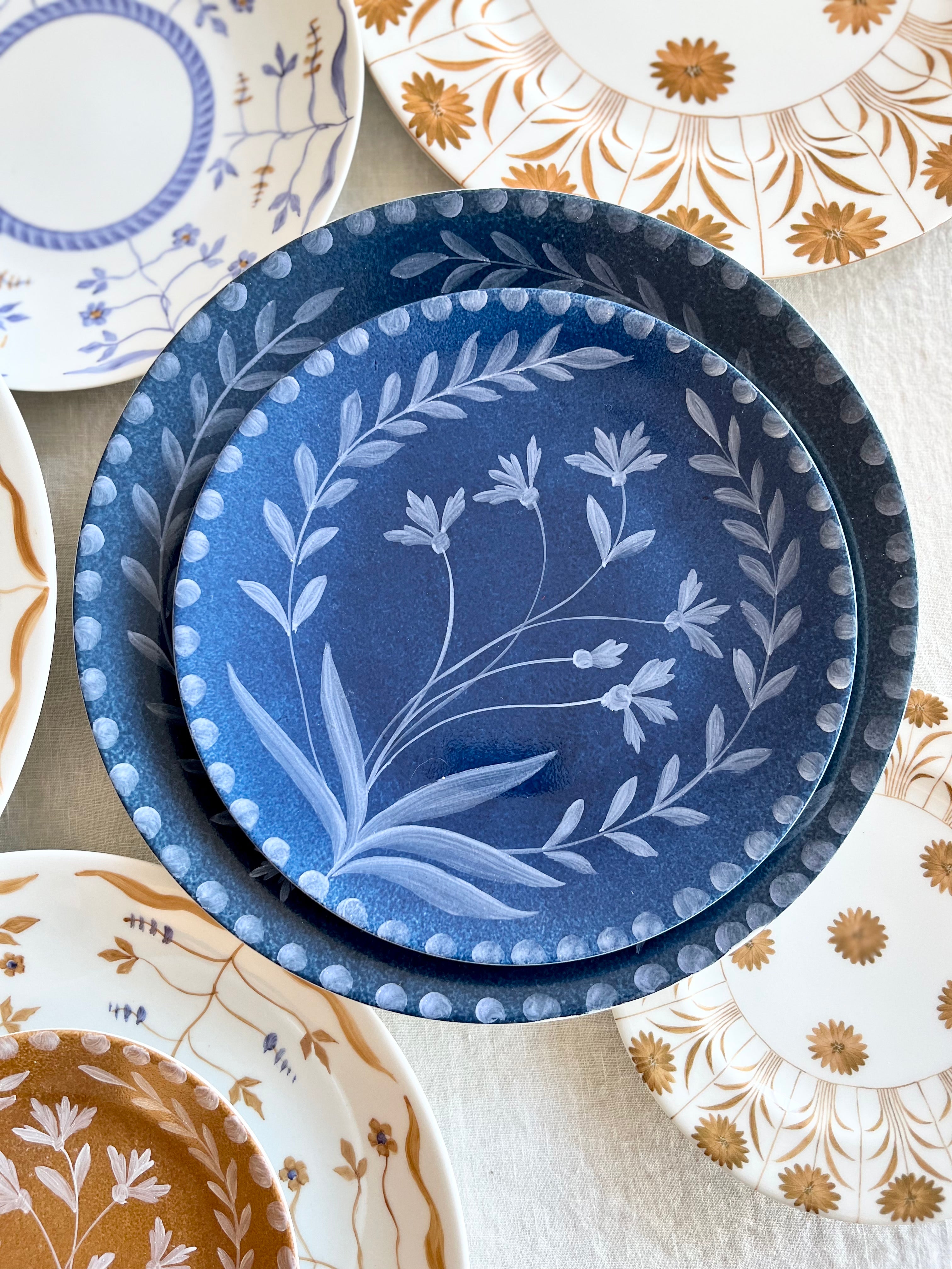 blue dinner plate with hand painted white floral design with salad plate