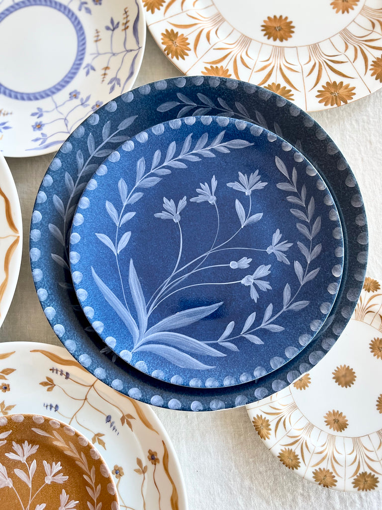 blue salad plate with hand painted white floral design with dinner plate