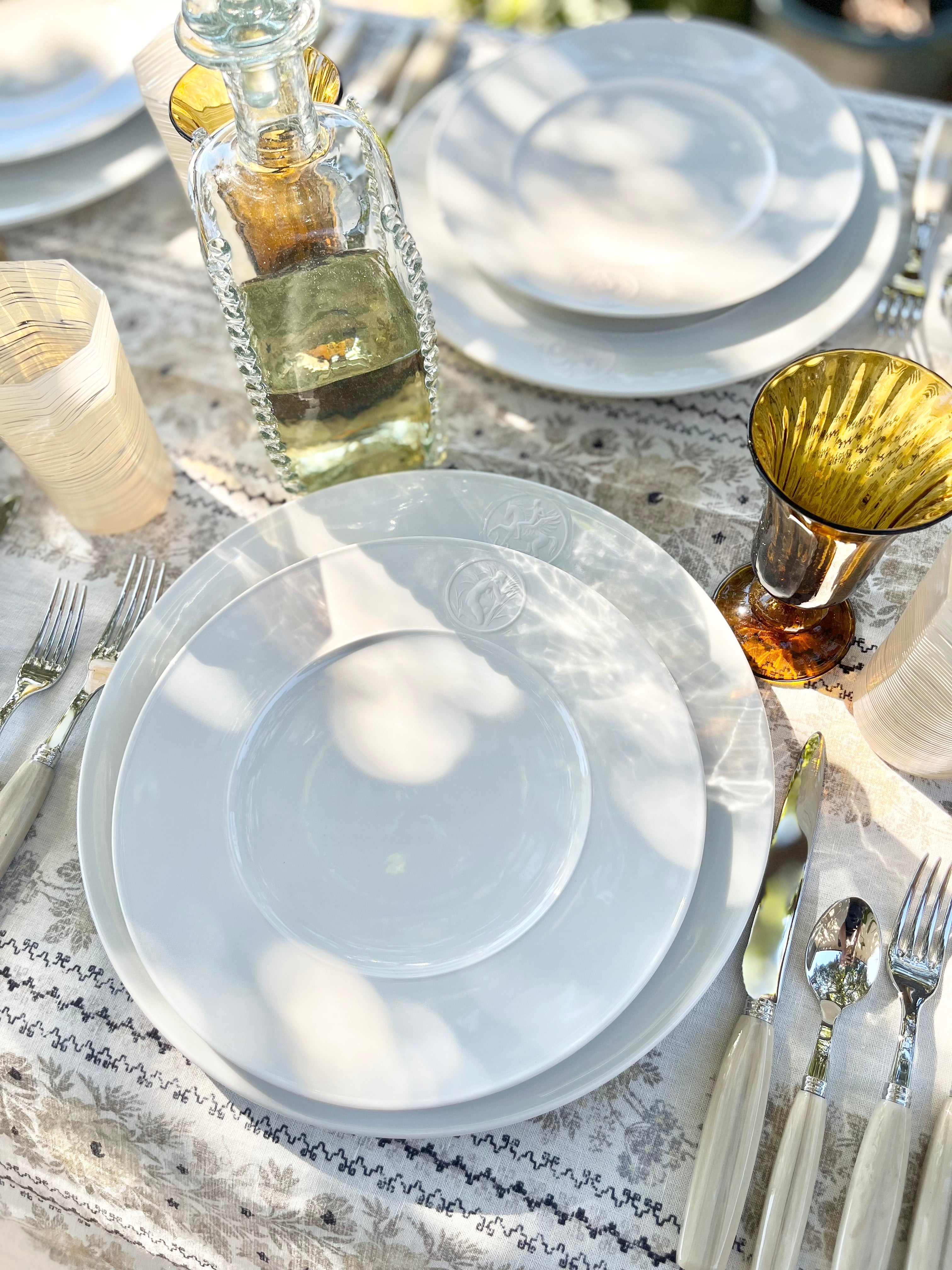 white dinner plate with greek medallion design in placesetting