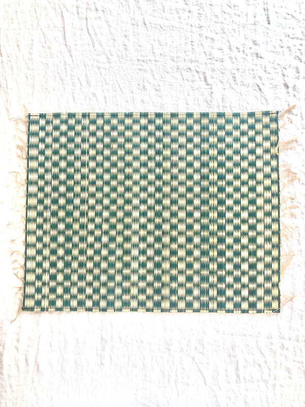 blue and white woven placemat with fringed ends