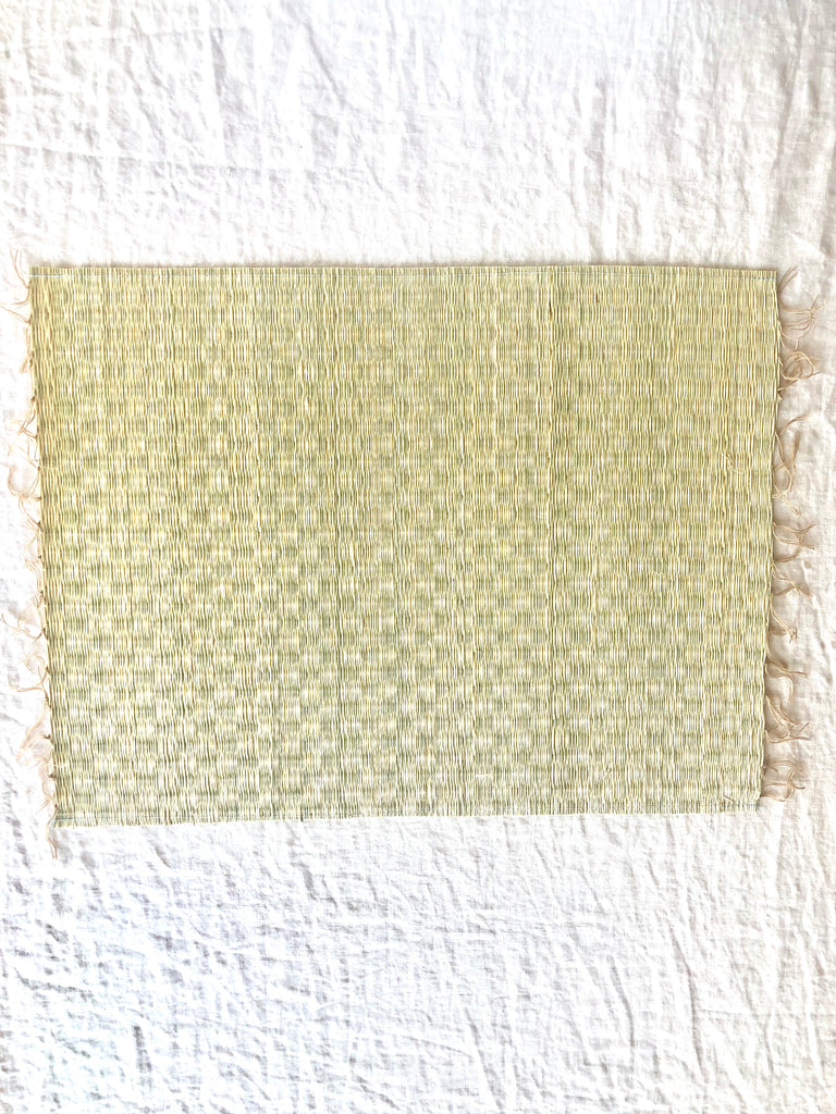 beige woven placemat with fringed ends