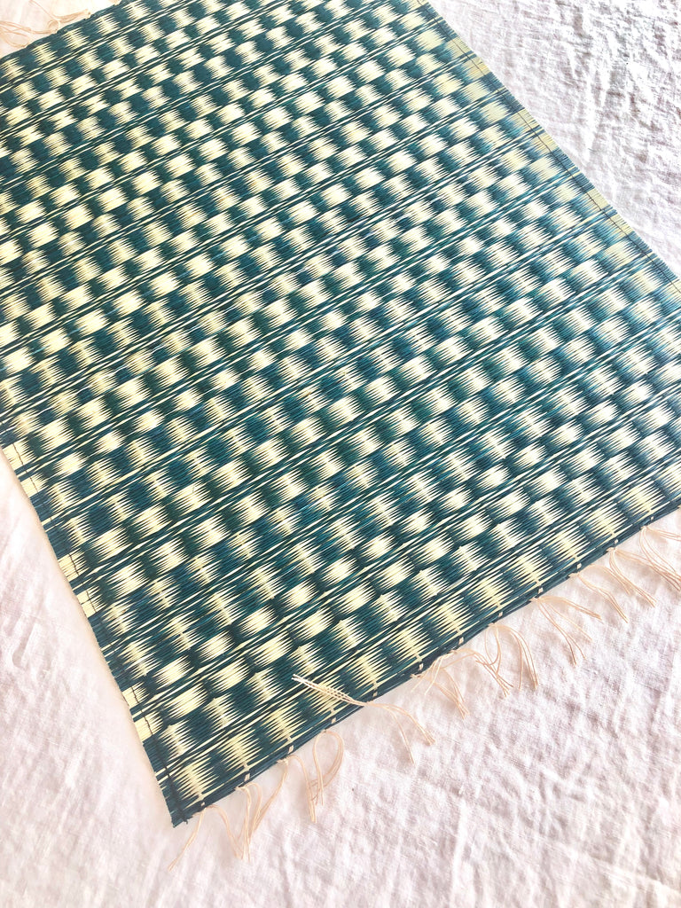 blue and white woven placemat with fringed ends detail view