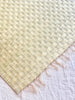 beige woven placemat with fringed ends detail view