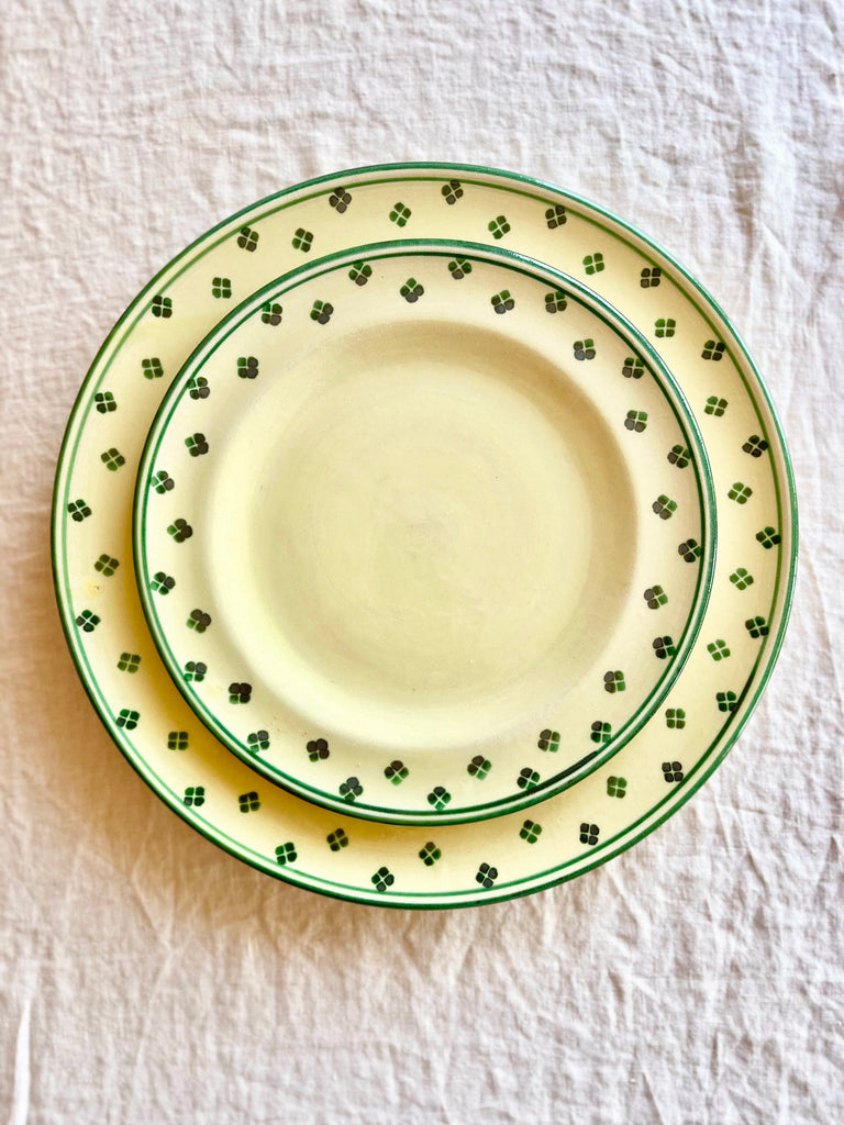 hand painted dinner plate with green rim and dots around edge in placesetting