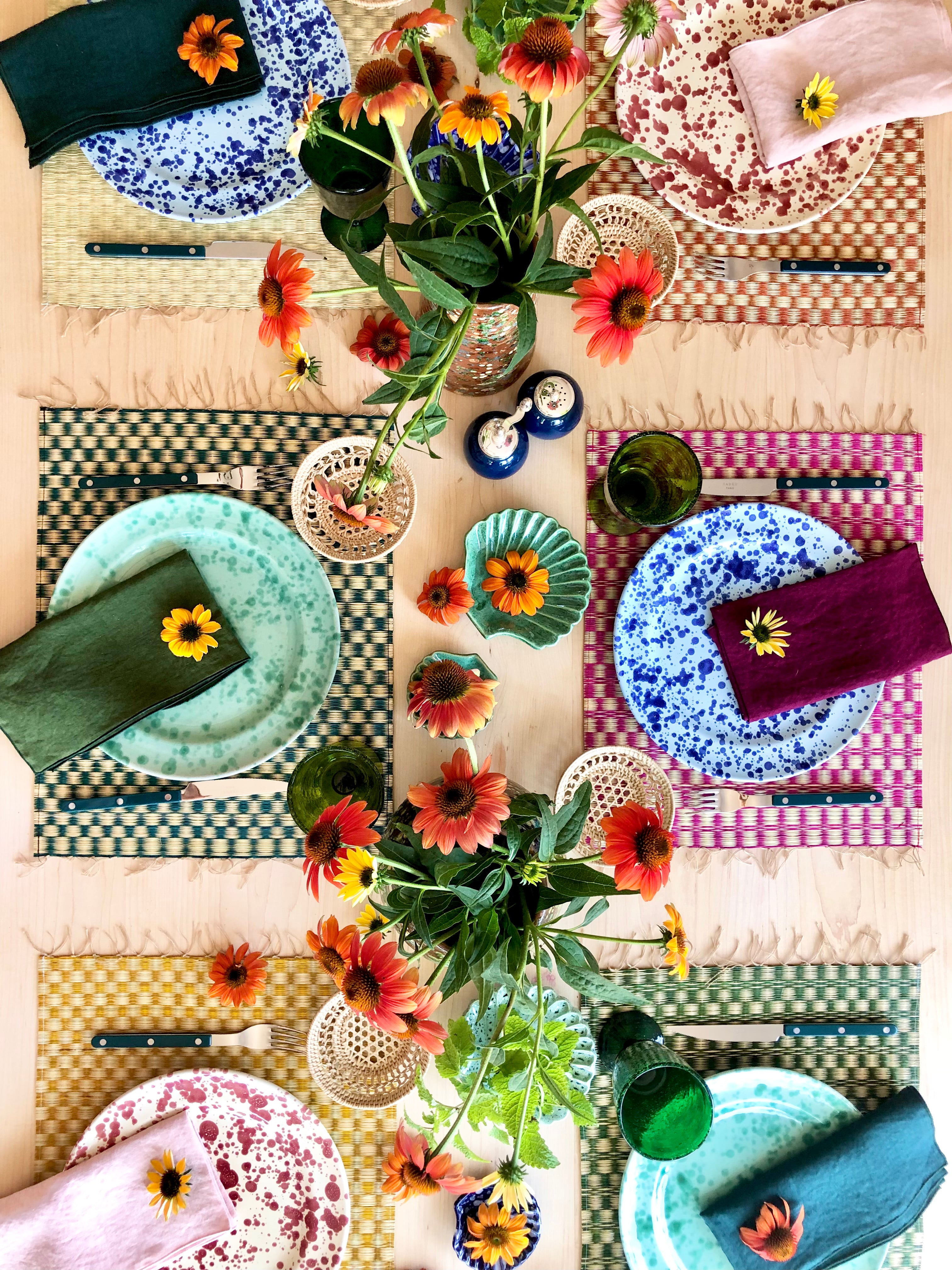 pink and white woven placemat with fringed ends in tablescape