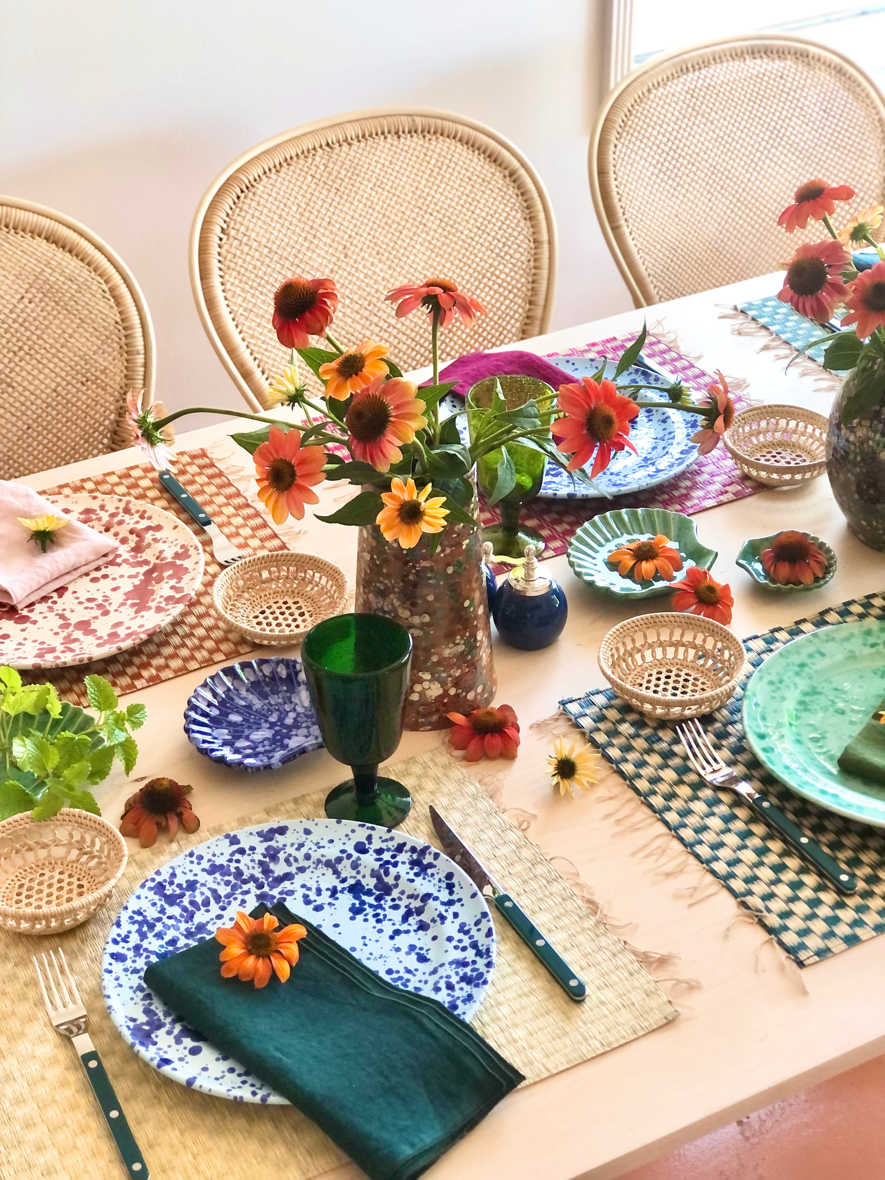 beige woven placemat with fringed ends with blue speckled plate