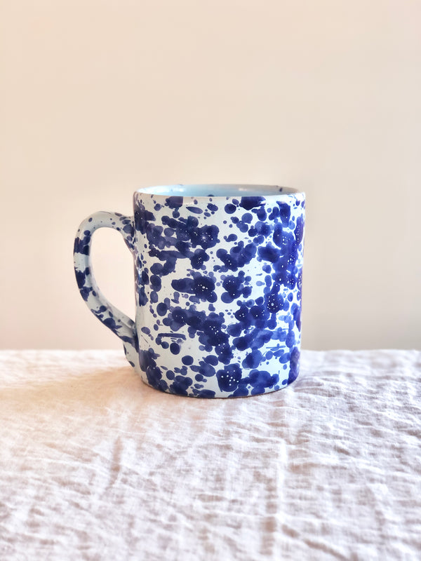 white fasano mug with blue splatter pattern