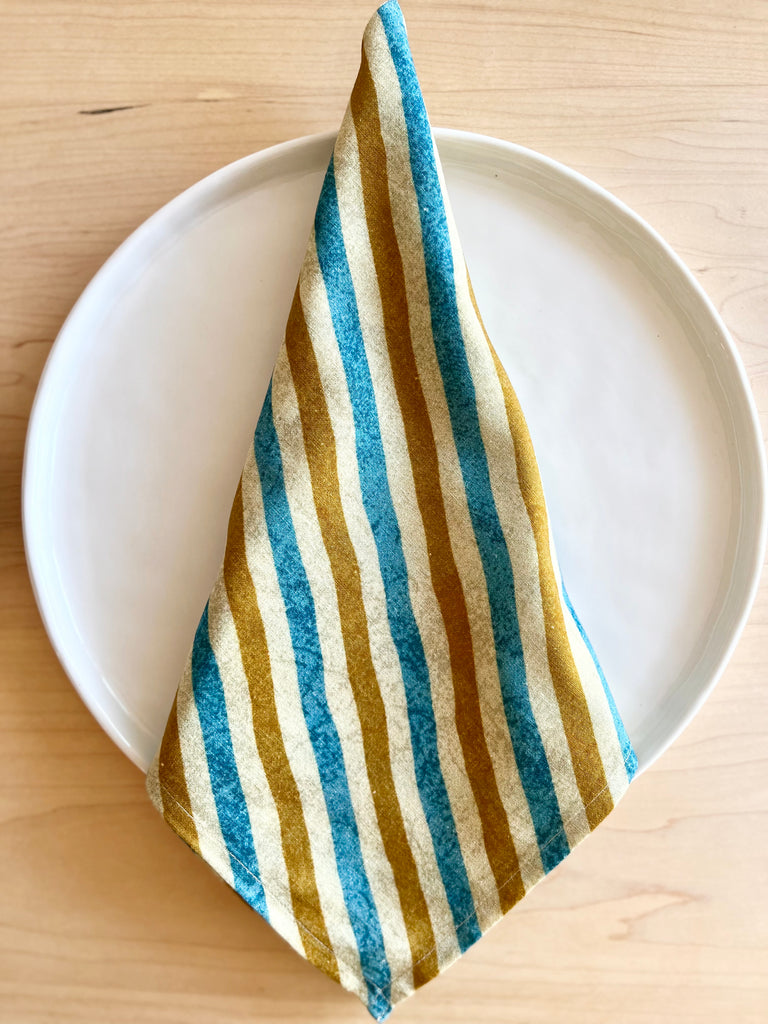 blue and gold cotton napkins 20 inch folded on a plate