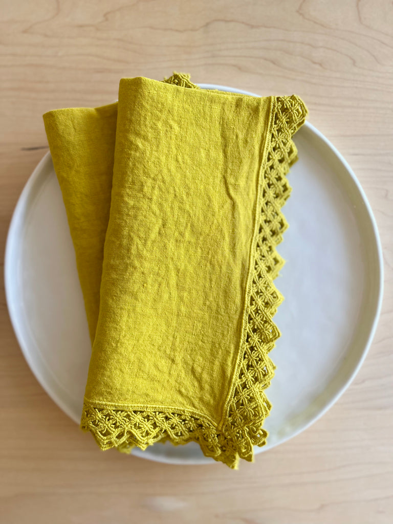 chartreuse linen napkin with macrame edge 18 inches square folded on plate