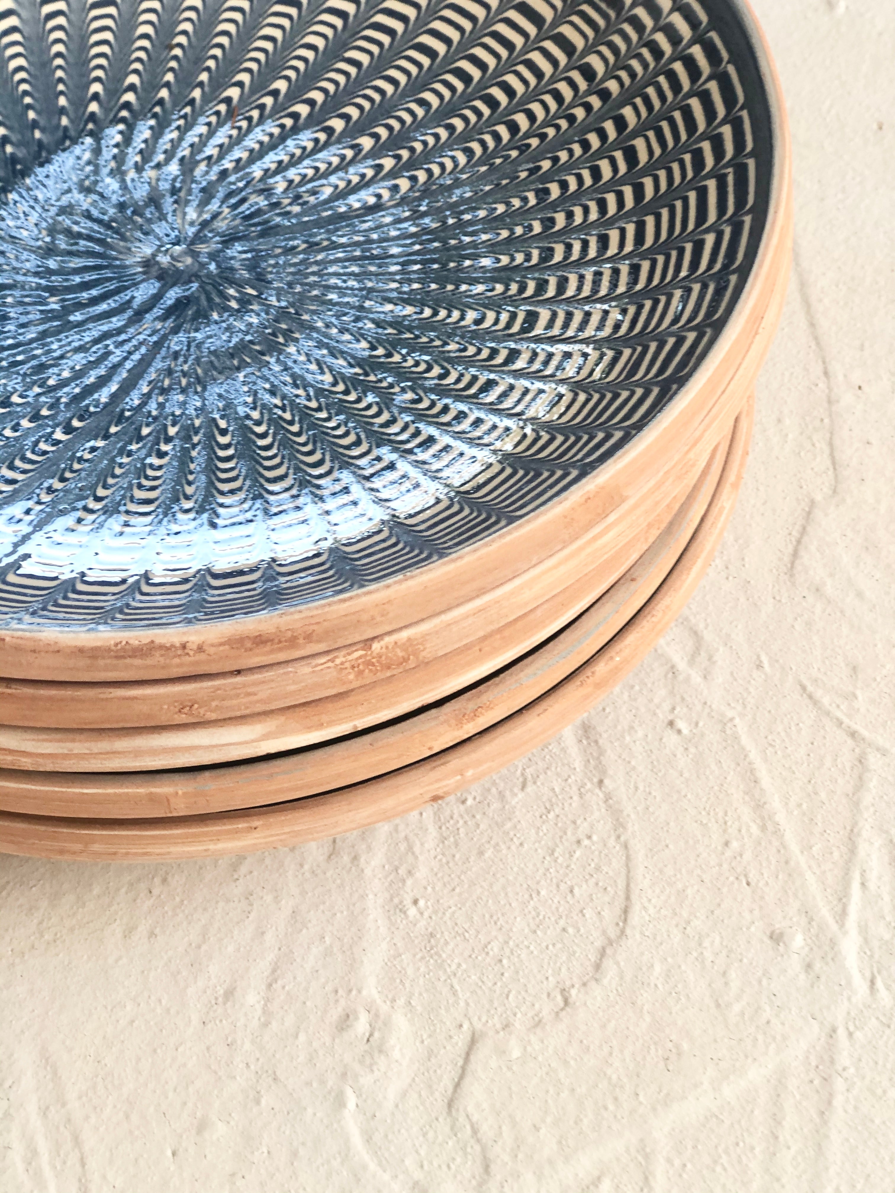 blue and white dinner plate with radial peacock pattern  side view