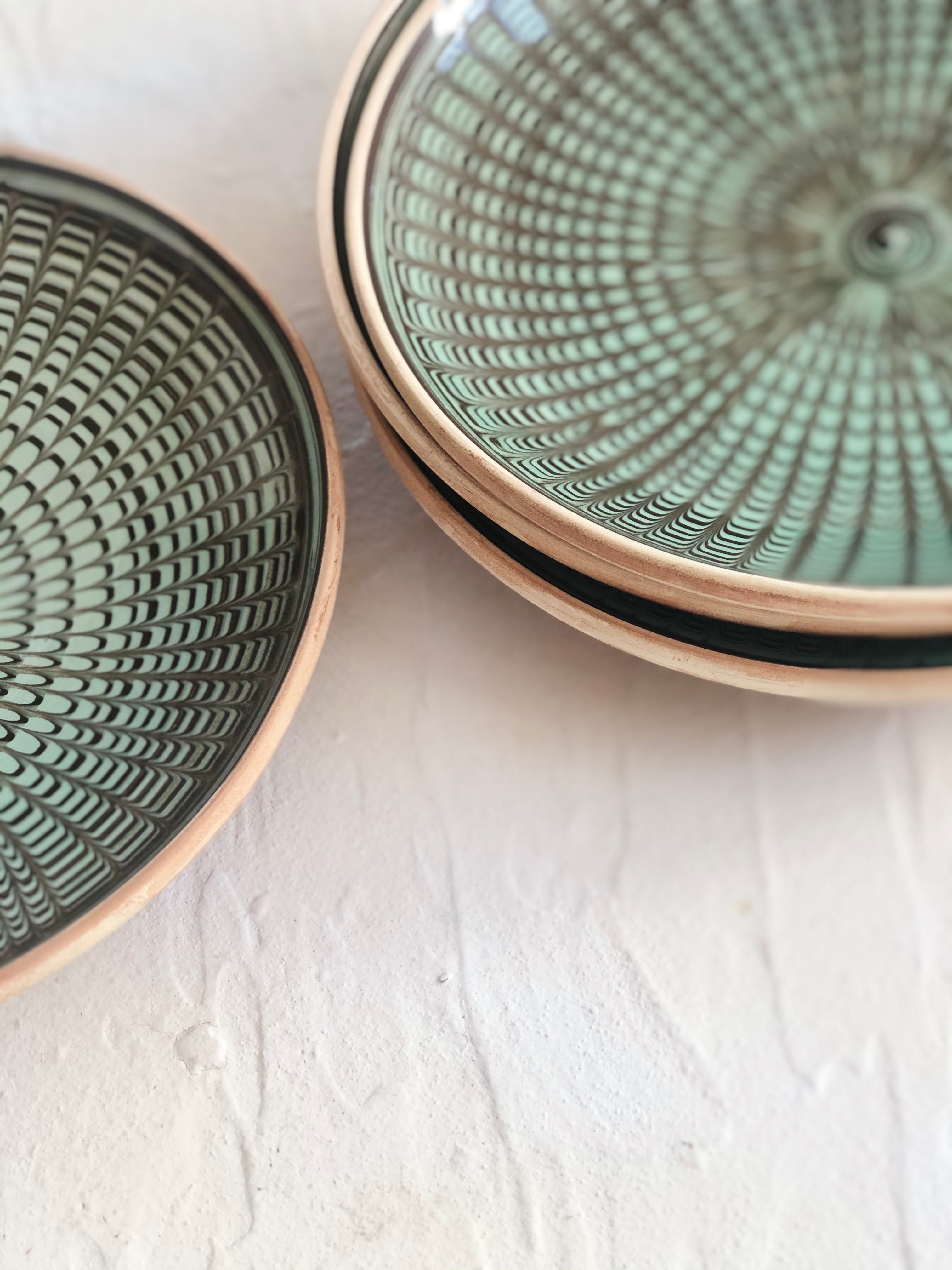 green and black salad plate with radial peacock pattern side view