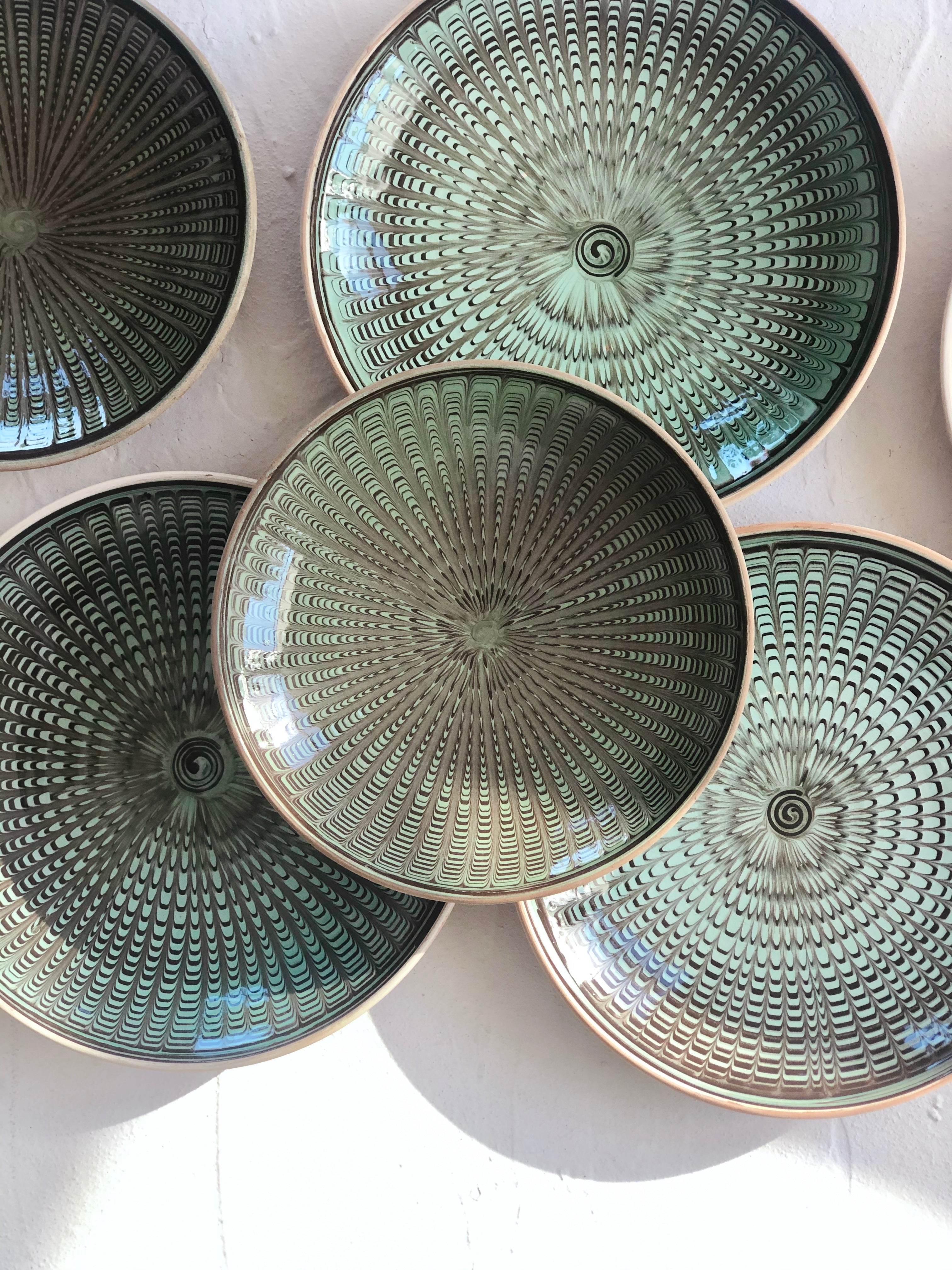 green and black salad plate with radial peacock pattern in group