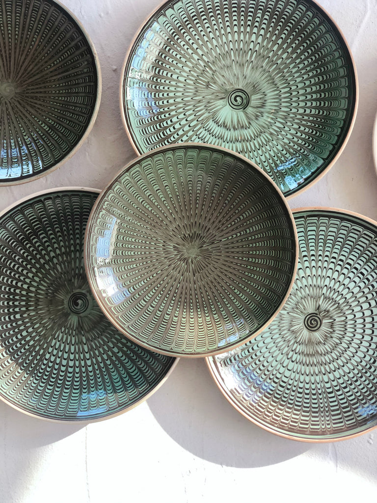 green and black salad plate with radial peacock pattern in group