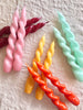 pink twisted taper candles on white table
