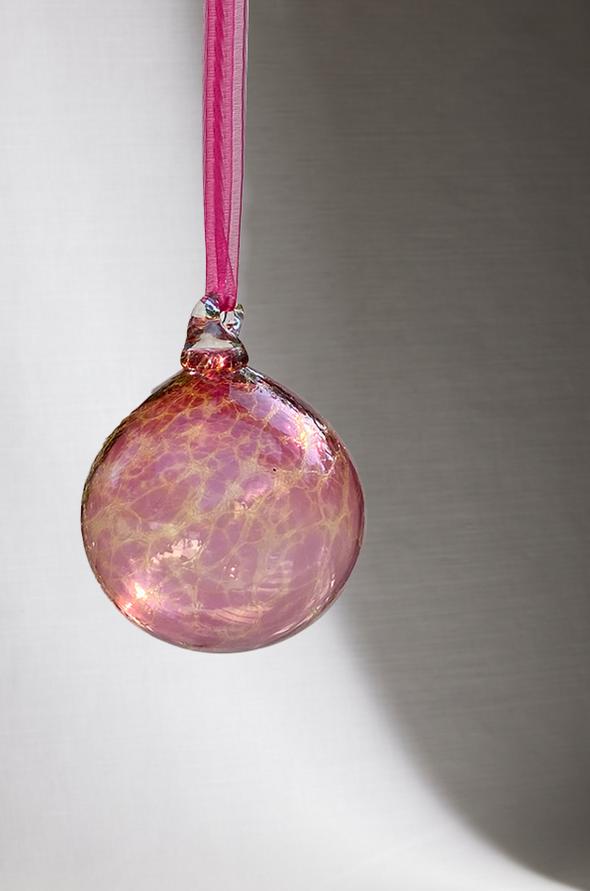 hand blown glass ornament with pink and yellow speckle pattern with white background