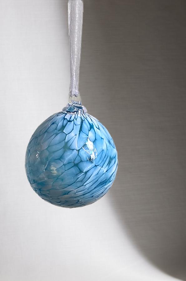 hand blown glass ornament with blue speckles with white background