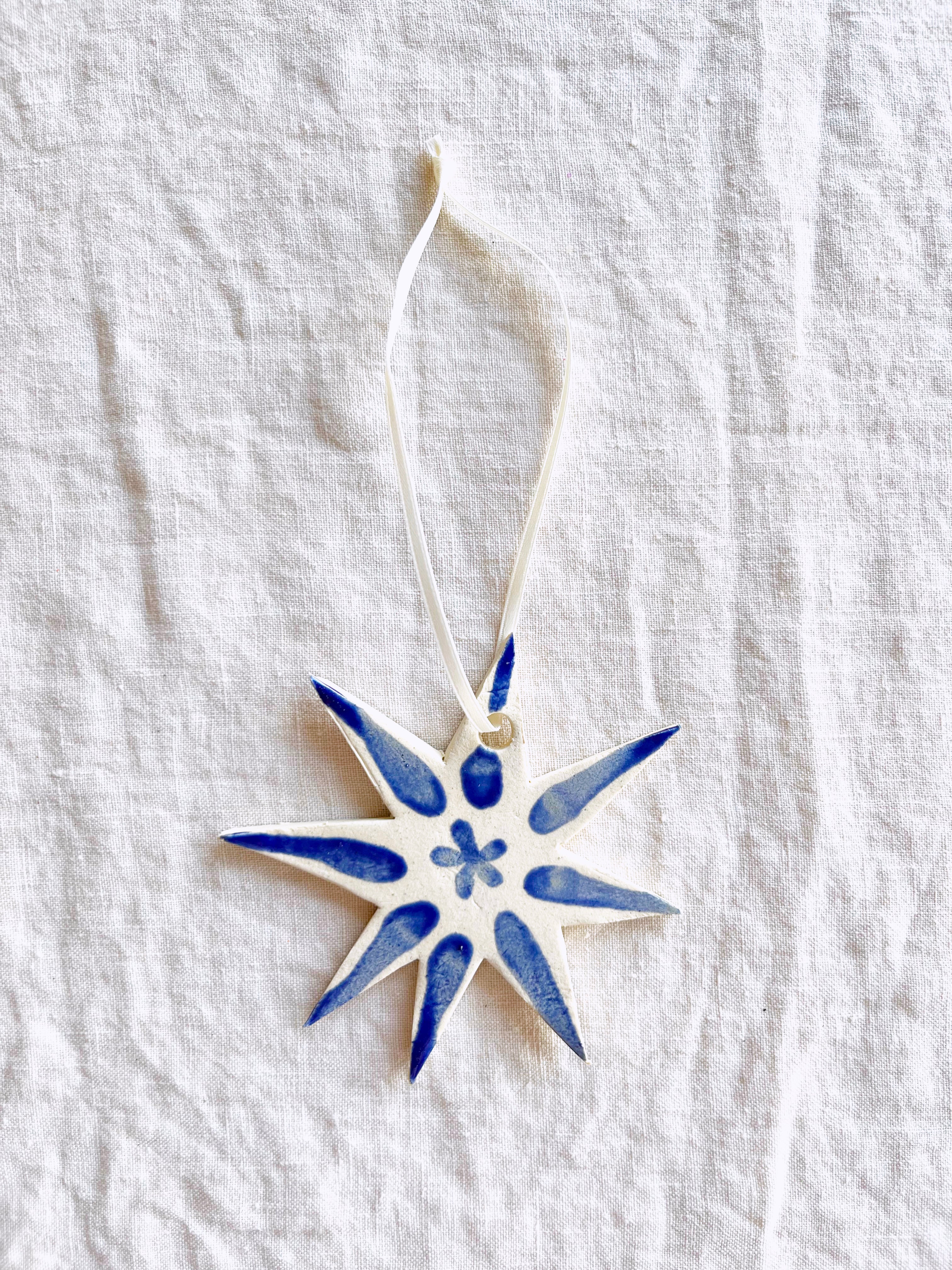 hand painted blue and white star christmas ornament on linen tablecloth