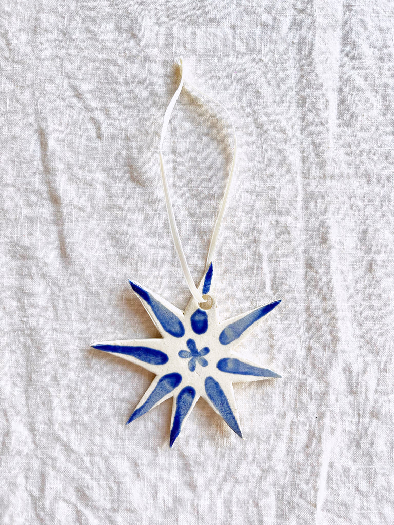 hand painted blue and white star christmas ornament on linen tablecloth