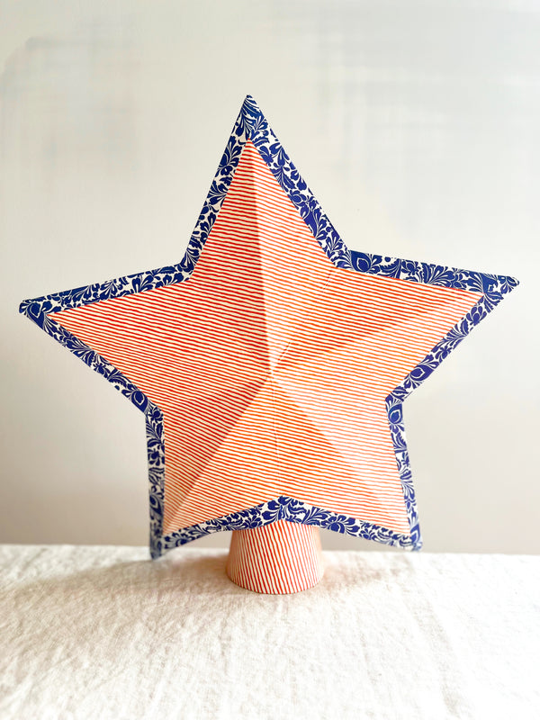star tree topper with thin red and cream stripe pattern