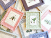 blue and white interlocking ring print paper wrapped frame and mat with pink botanical print 12" by 15" shown with other color options