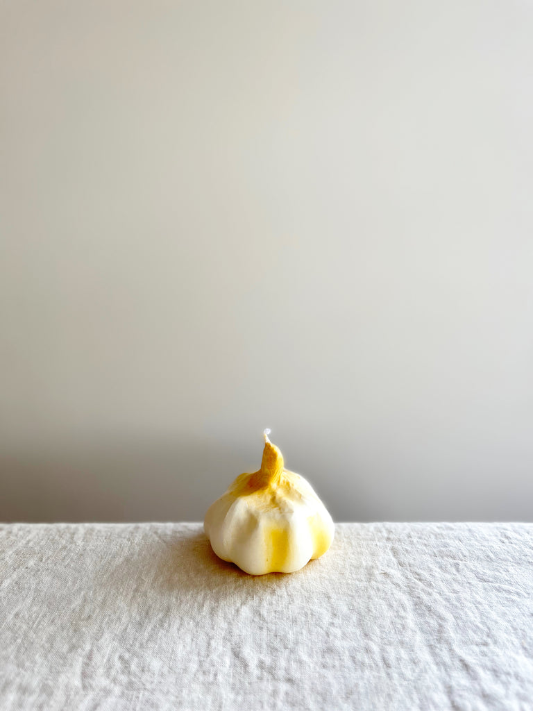 cereria introna garlic shaped paraffin candle on white table