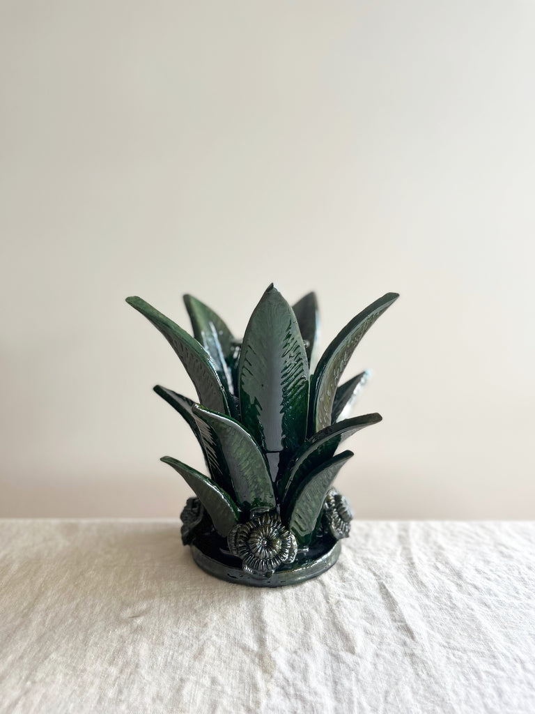 green taper candle holder shaped like the top of a pineapple