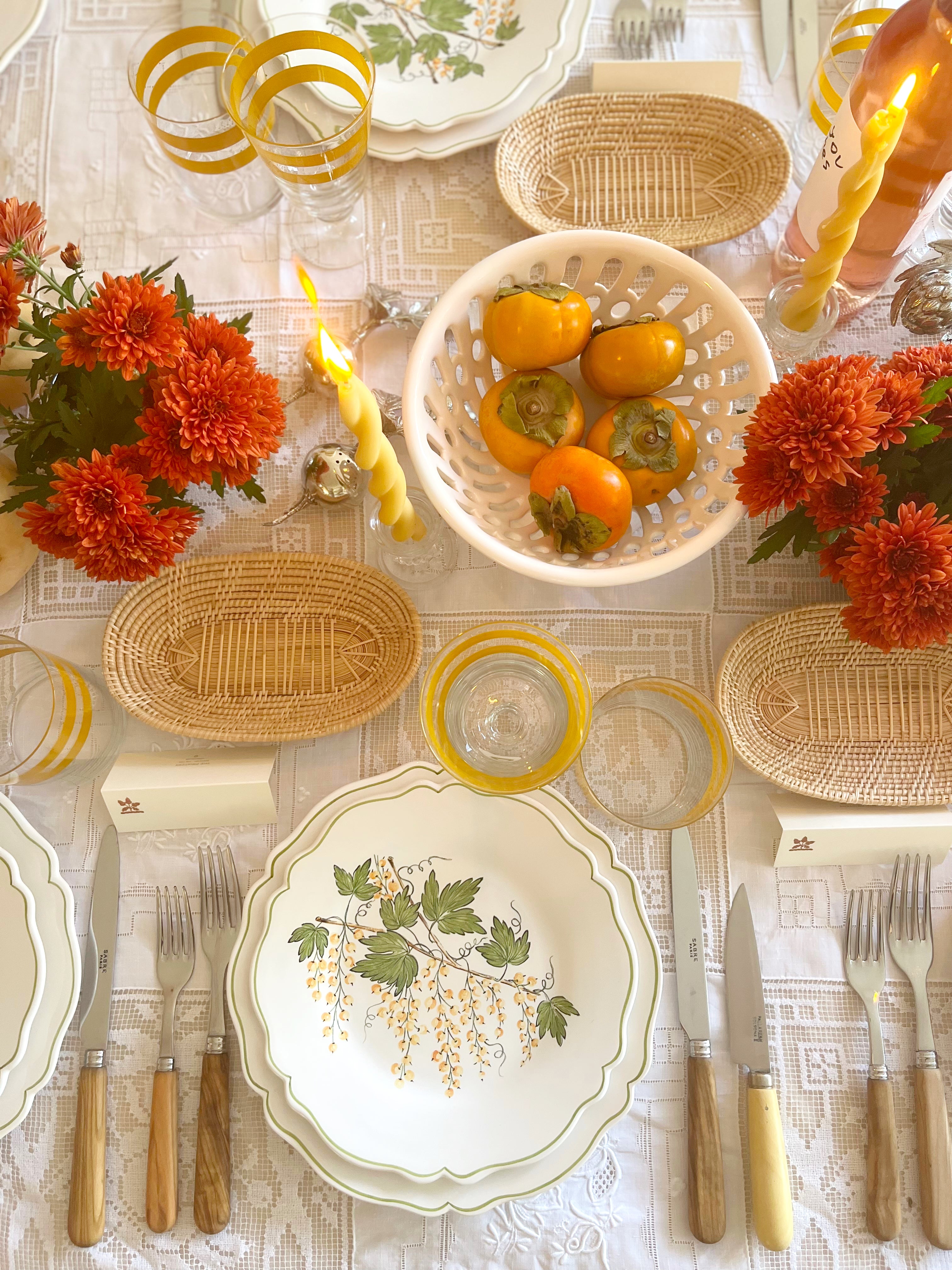 charger plate with green leaves and currants on white tablecloth