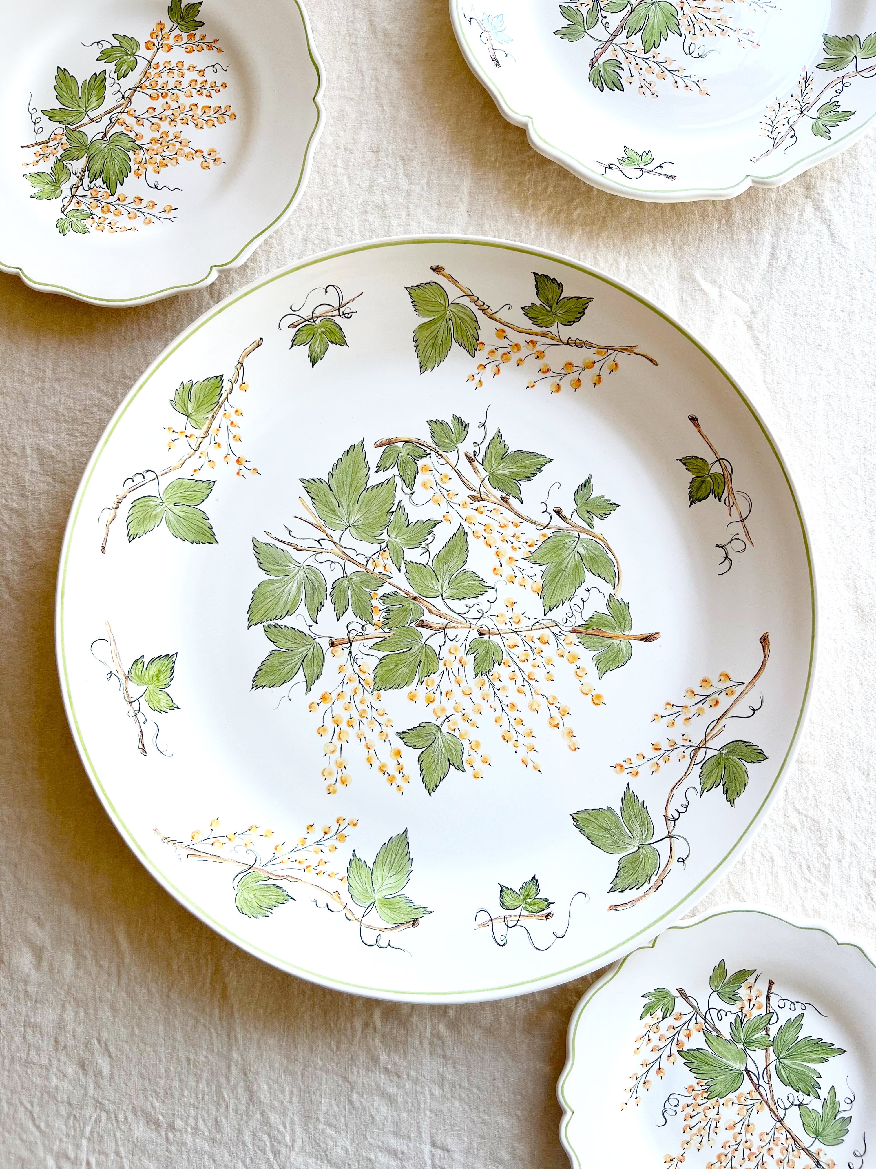 charger plate with green leaves and currants grouping