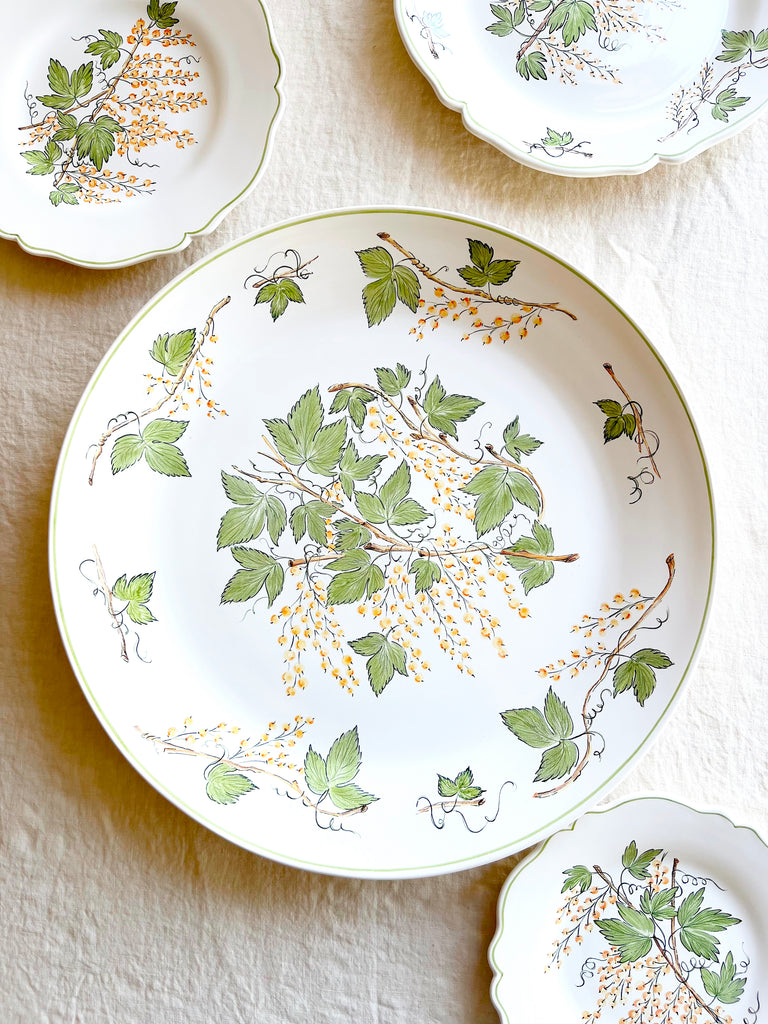serving platter with green leaves and currants with plates