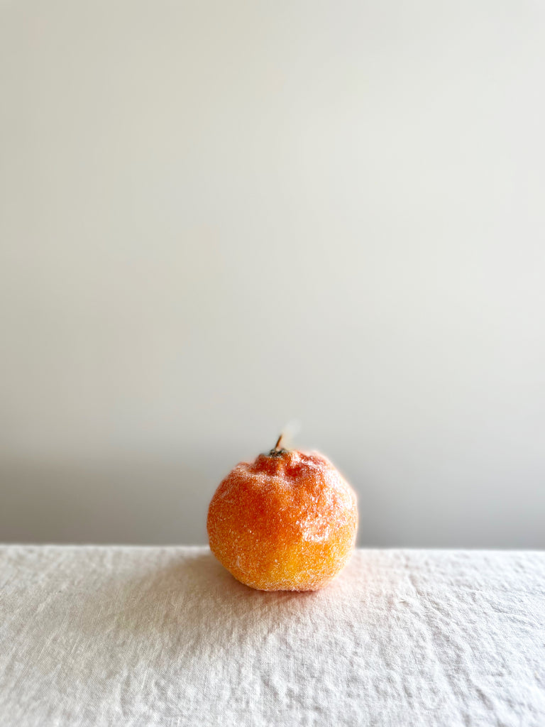 cereria introna sugared orange shaped paraffin candle on white table