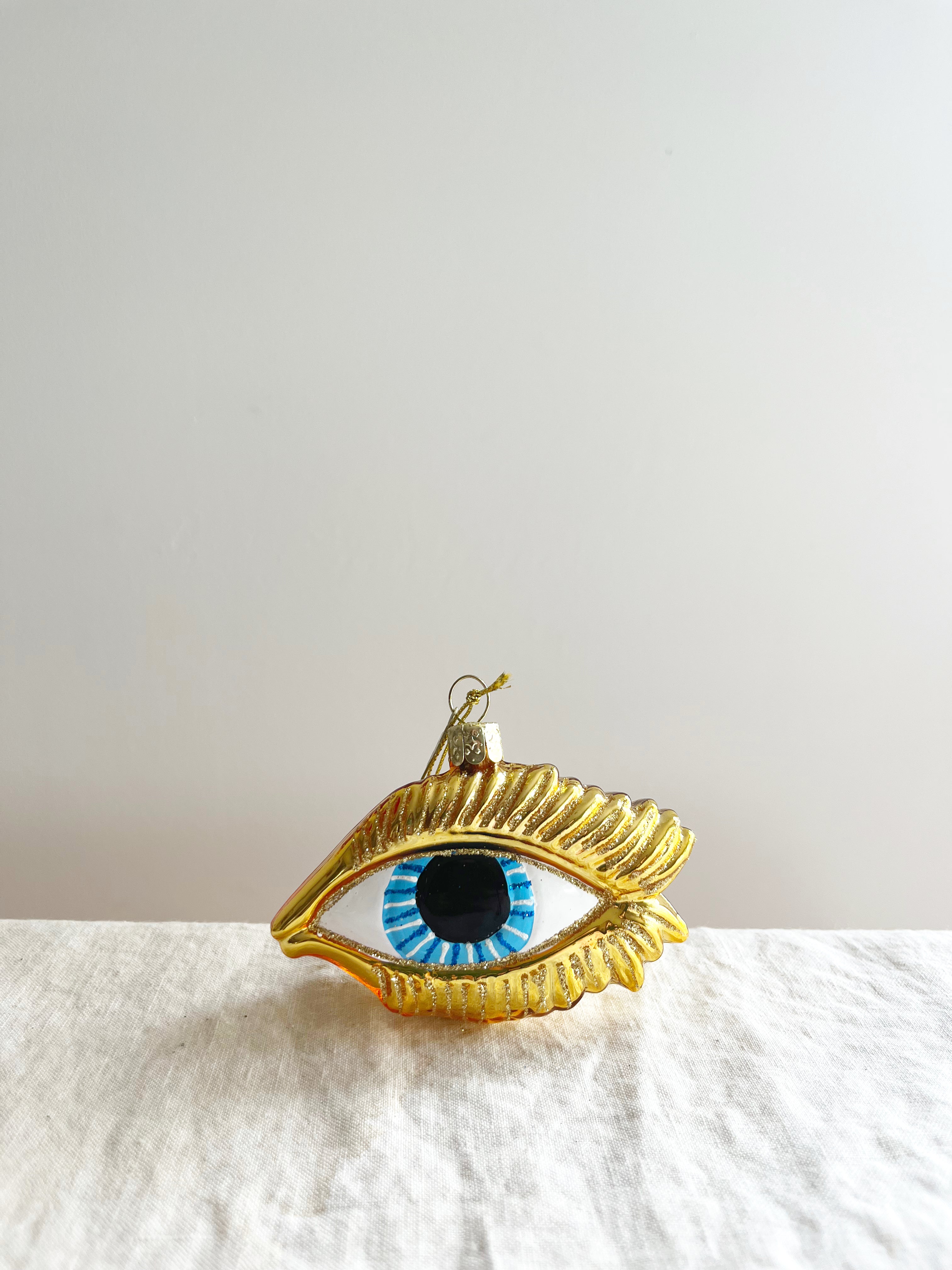 hand blown glass christmas ornament shaped like eye on white table