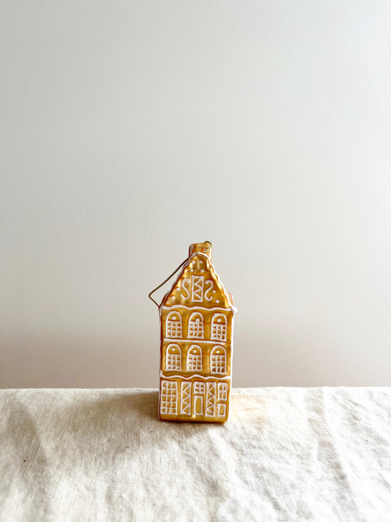 glass christmas ornament shaped like gingerbread house on table