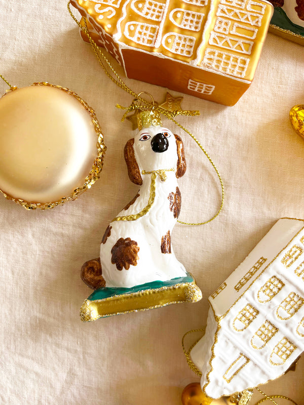 brown and white dog glass christmas ornament on linen tablecloth