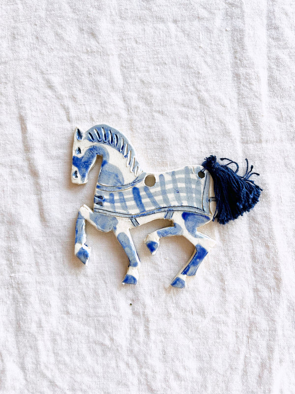 blue and white hand painted christmas ornament in shape of horse detail view