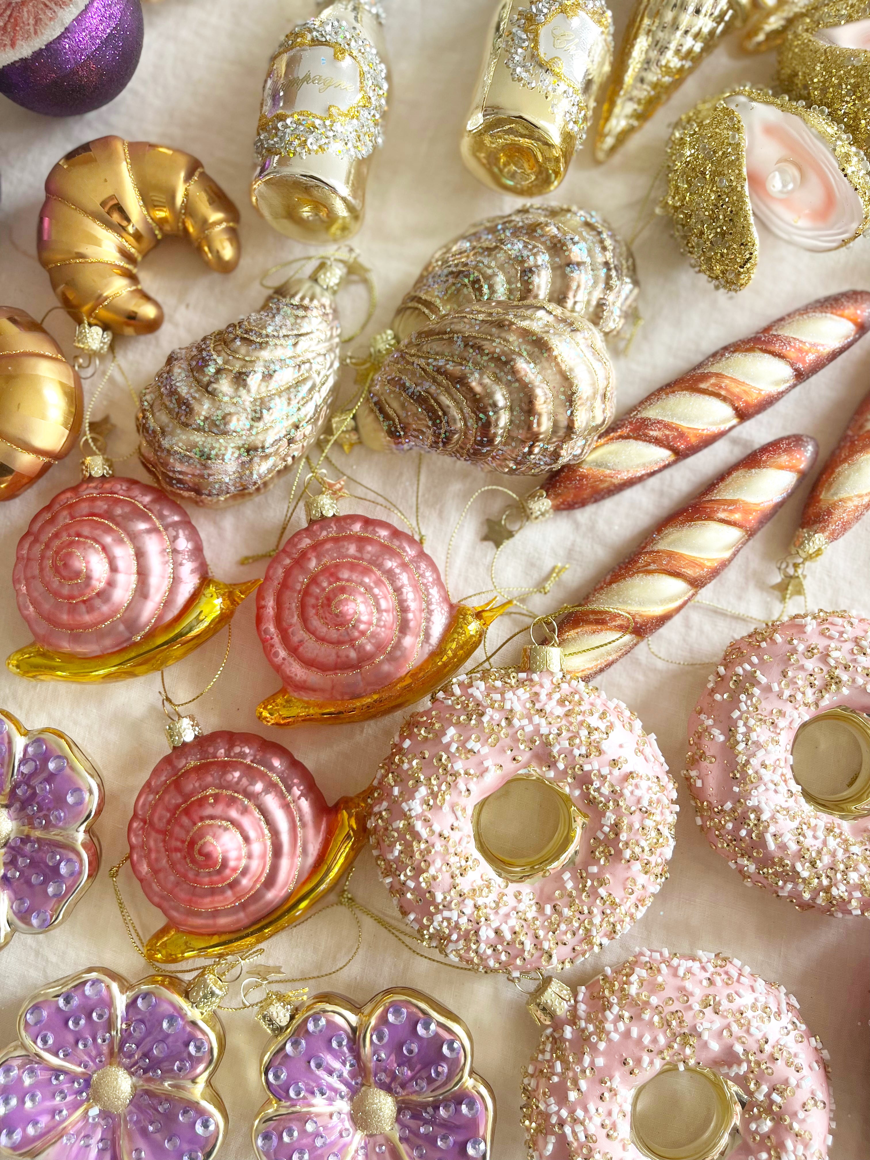 glass christmas ornament shaped like croissant in group with other ornaments