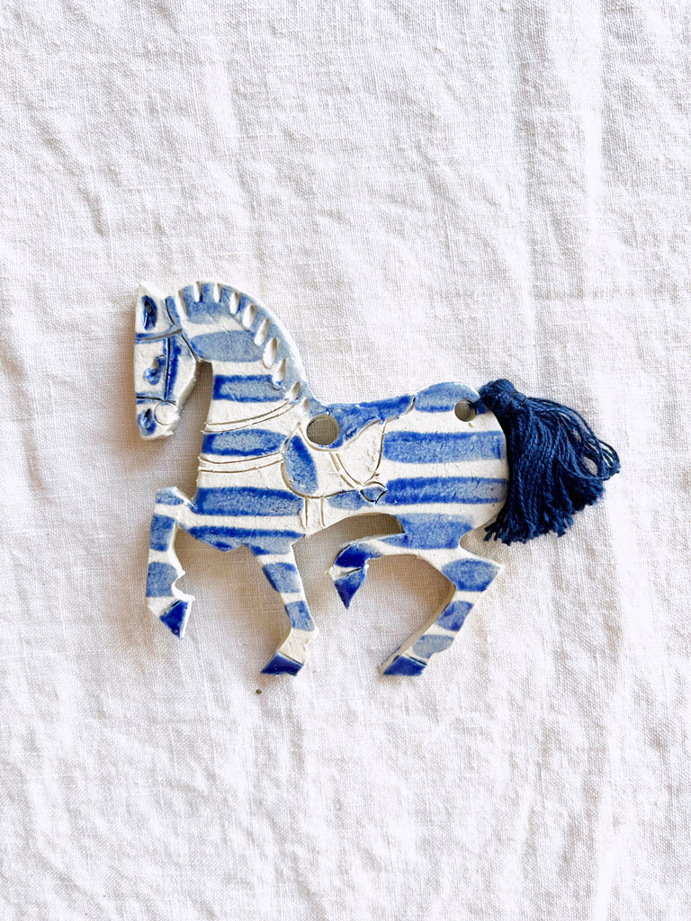 blue and white hand painted christmas ornament in shape of horse with ribbon tail