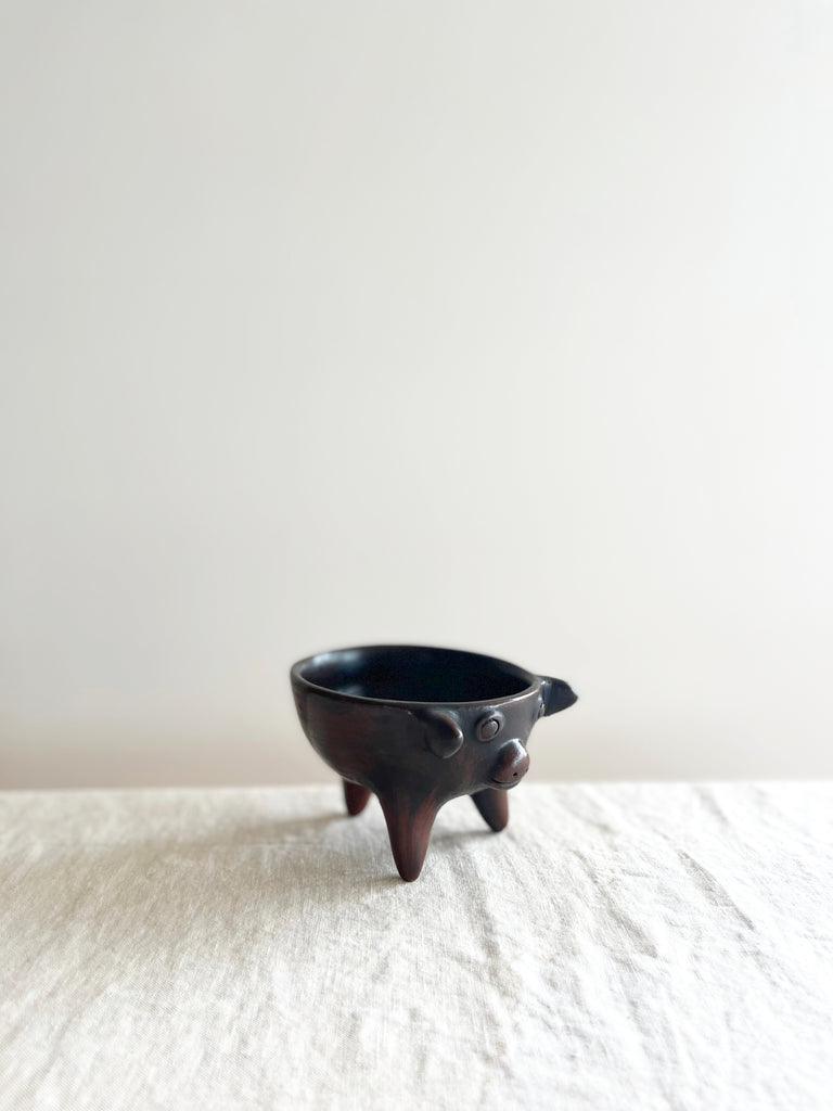 brown piggy salsa bowl with three feet on white table