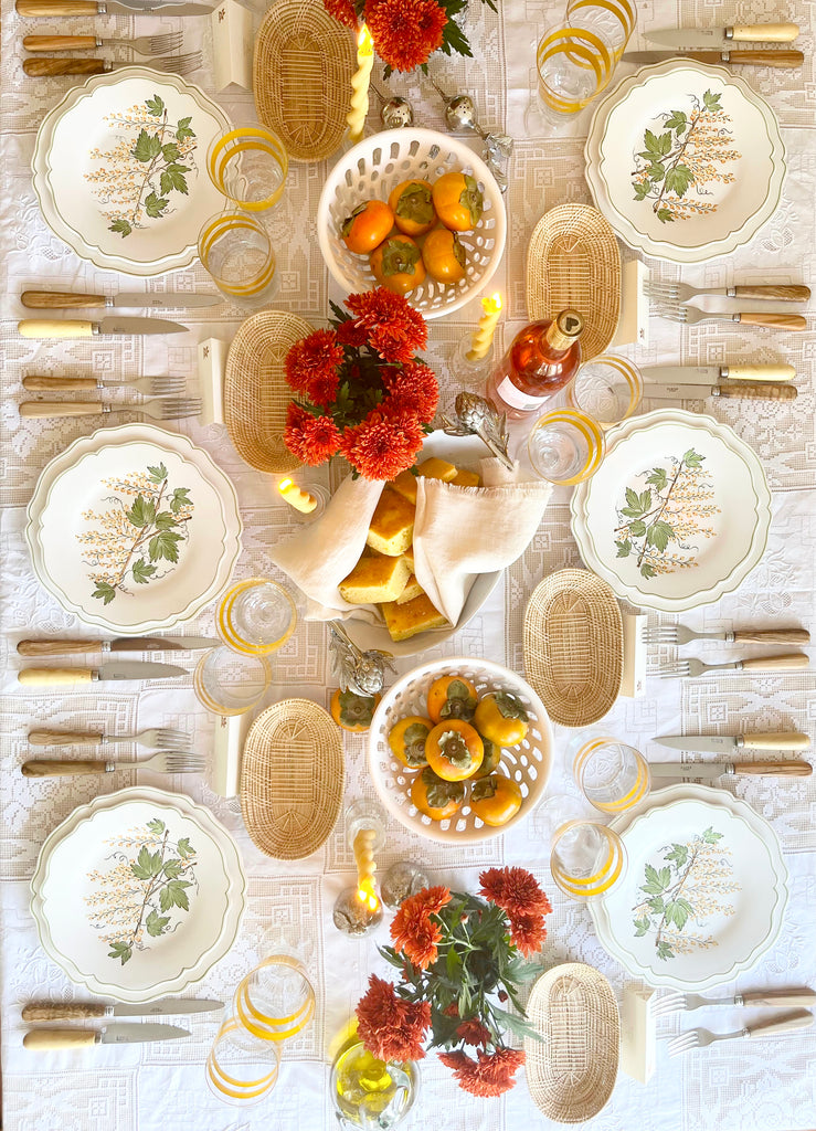 serving platter with green leaves and currants on white tablecloth