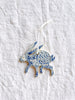 blue and white hand painted christmas ornament in shape of rabbit with white ribbon