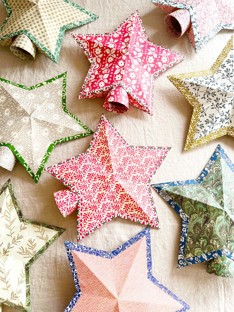 star tree topper with thin red and cream stripe pattern on linen tablecloth