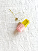 pink and gold glass christmas ornament shaped like a capsule with chill pill written on side detail view