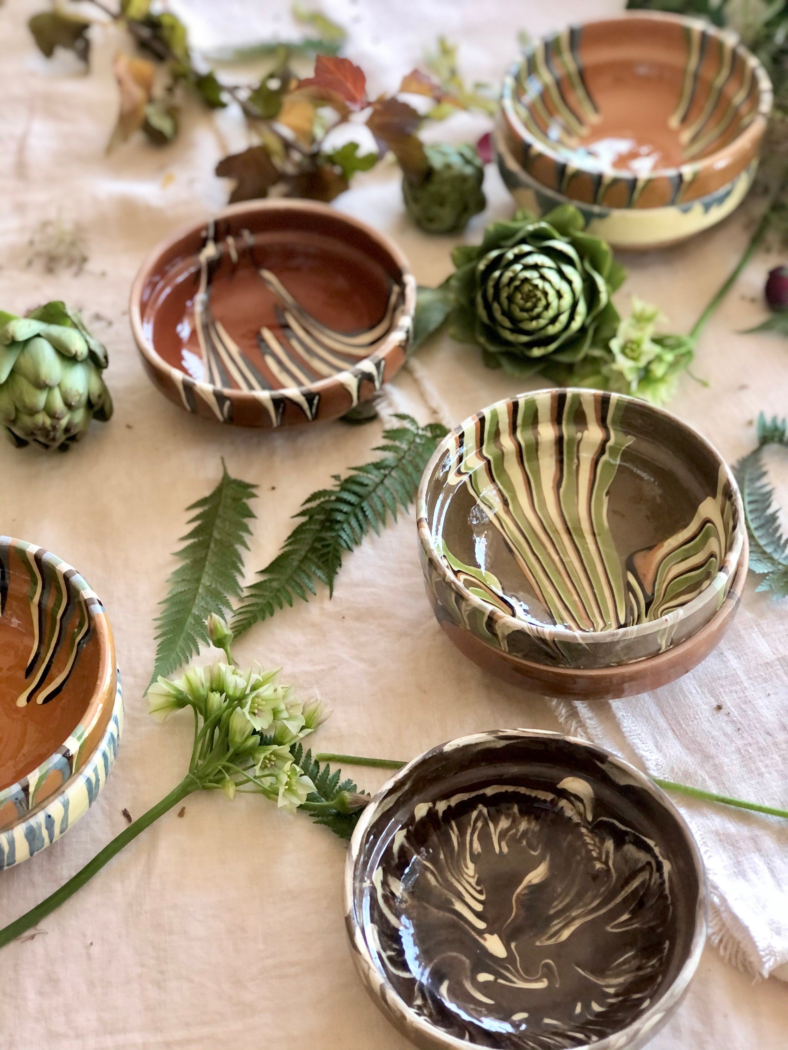 multicolor ceramic bowls group on white tablecloth