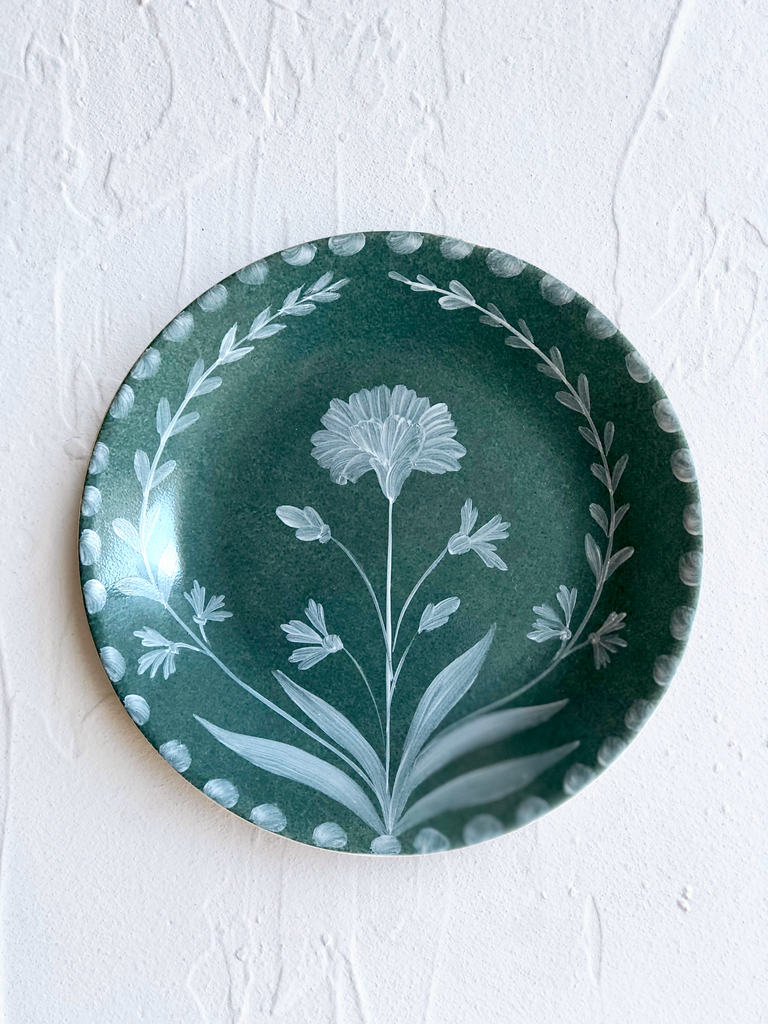green dinner plate with hand painted white floral design detail view