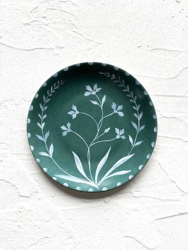 green salad plate with hand painted white floral design on white table