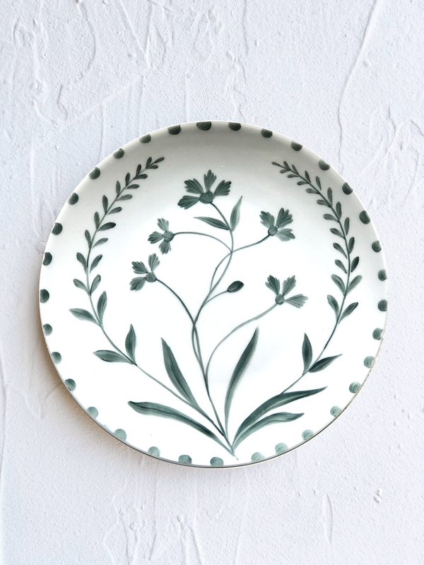 white porcelain dinner plate with green floral pattern on white table