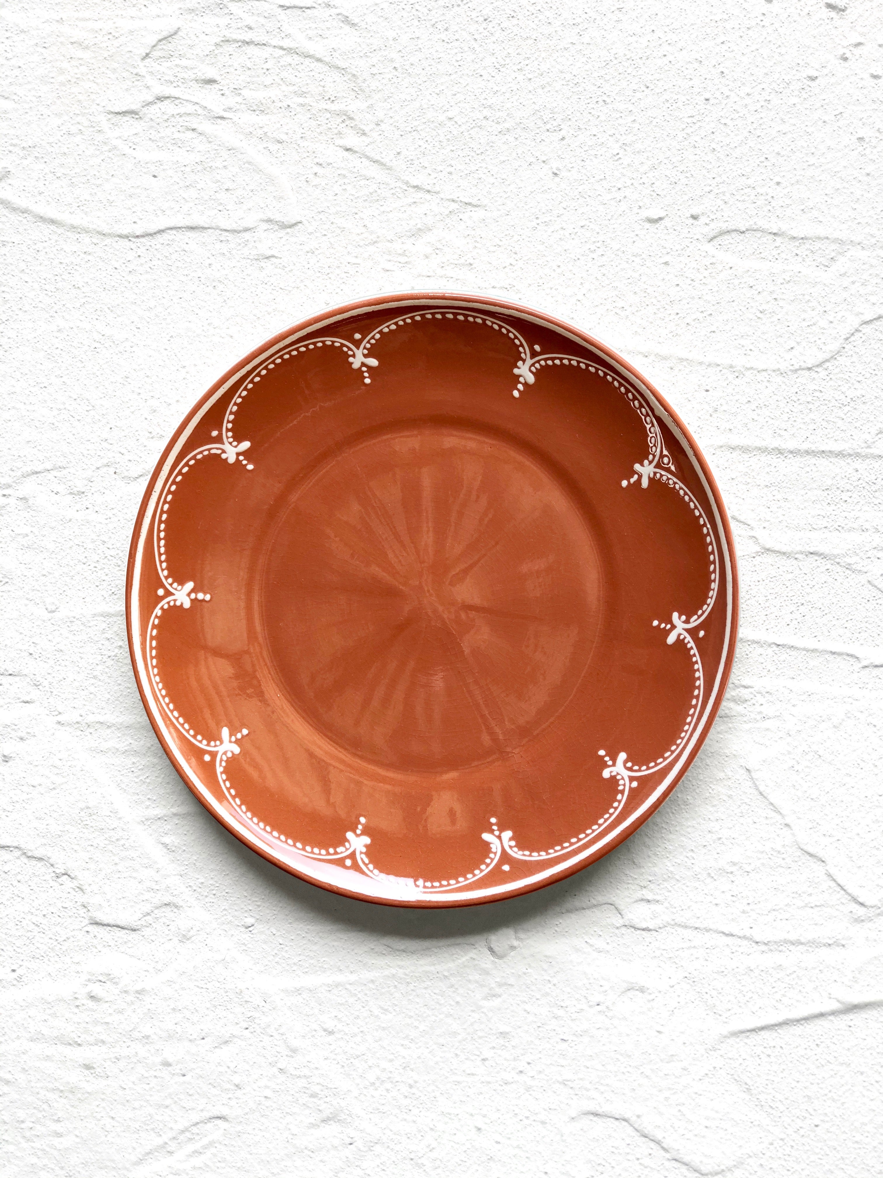 brown salad plate with white scallop design on rim