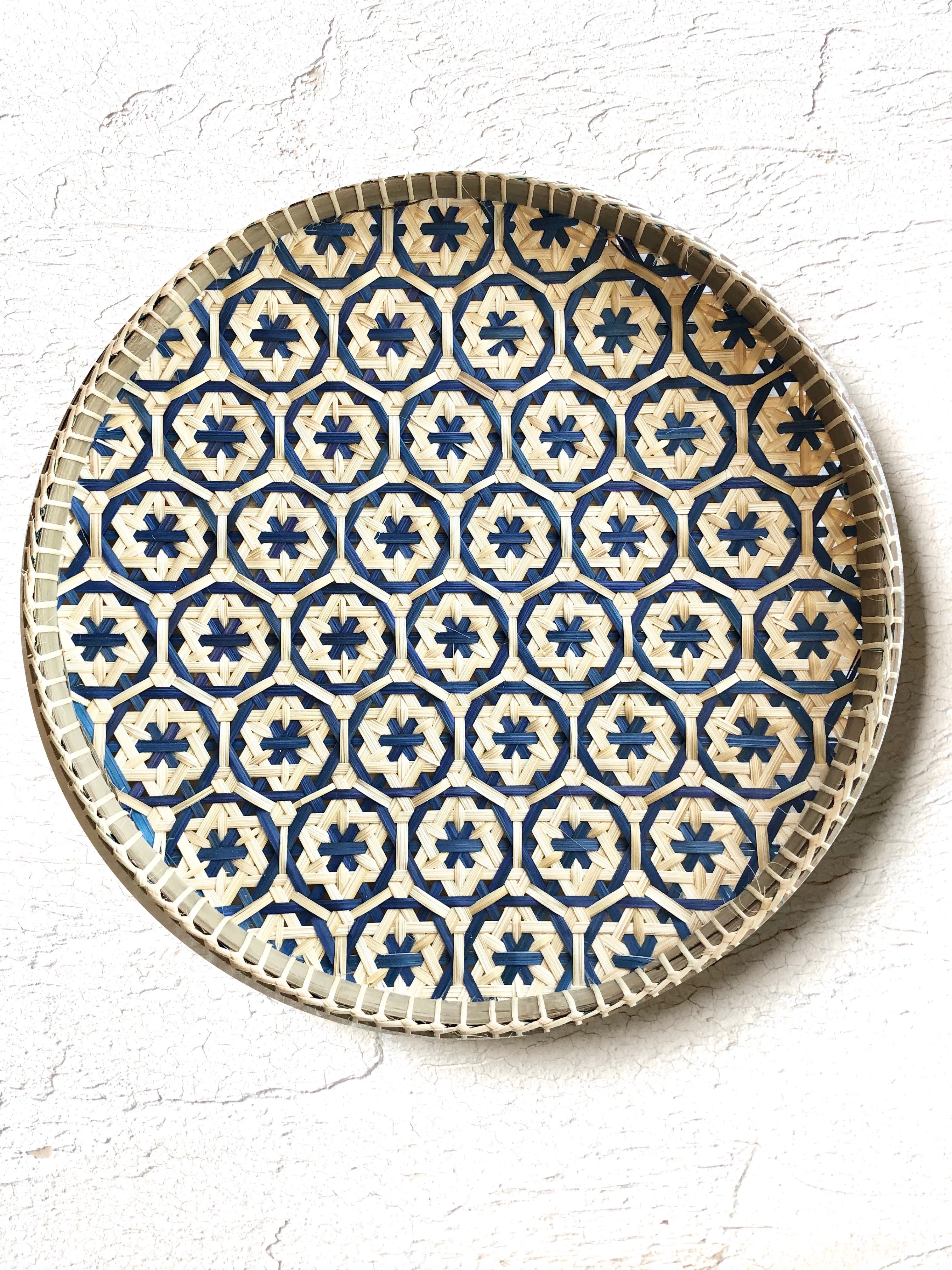 light tan woven tray with navy blue mosaic flower pattern 12 inches on white table