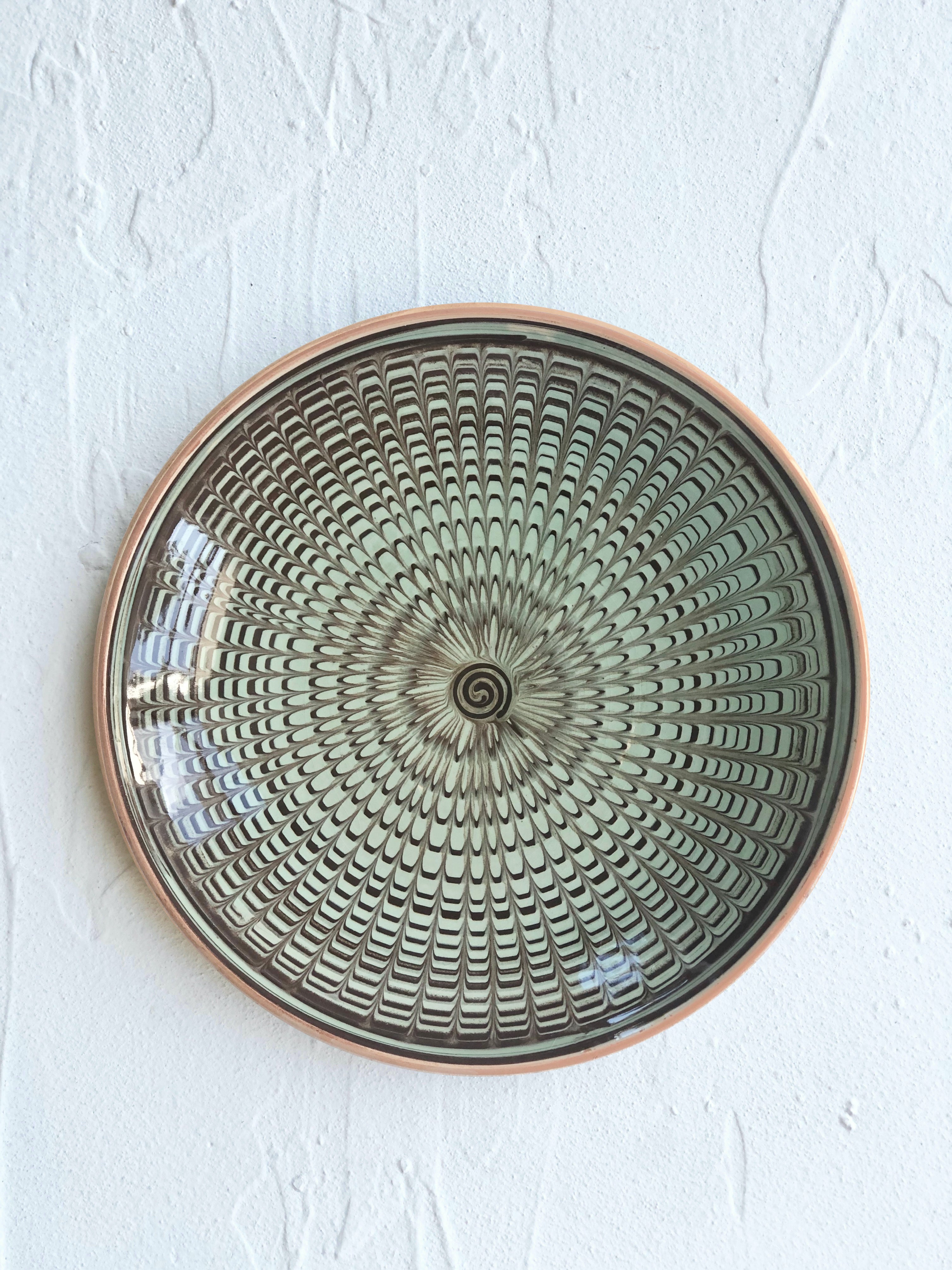 green and black dinner plate with radial peacock pattern 